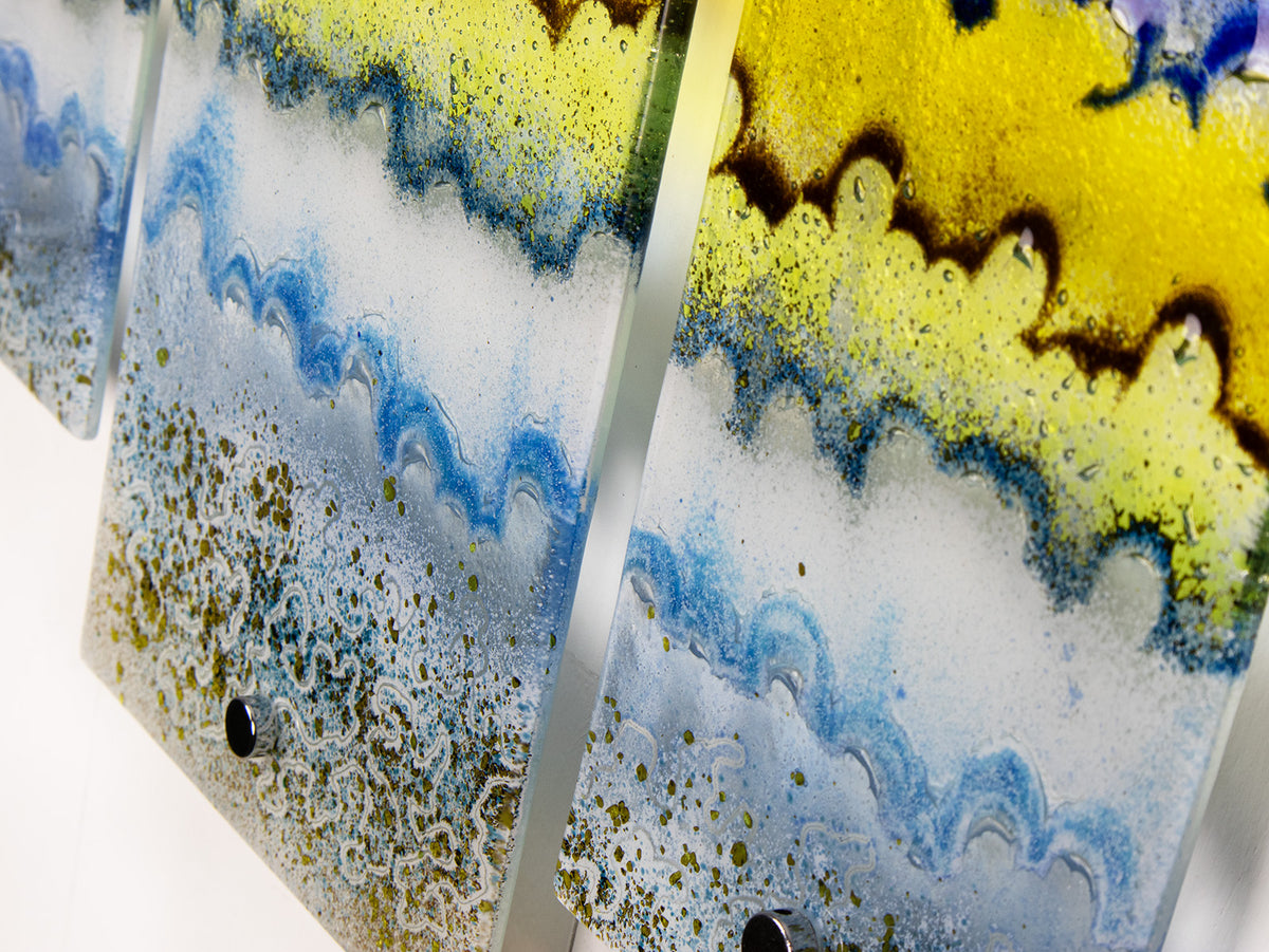 A close up of fused glass small triptych wall art piece, handmade in coastal, soft, organic colours, inspired by the Cornish beaches.