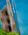 Close up of a Cornish tin mine on a fused glass triptych in coastal colours, a hand-made coastal wall art piece, with texture. 