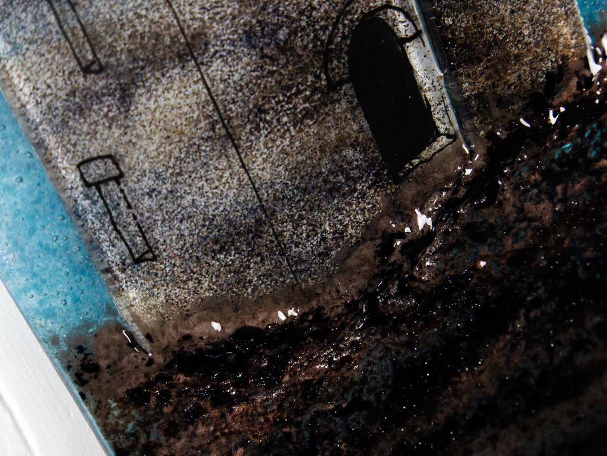 Textural details on a fused glass tin mine wall panel set against a moody dark sky, creating a soft Cornish inspired piece of wall art. 
