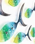 A close up of a fused glass ocean shoal of fish, in bright coastal yellows, purples, greens and blues. A vibrant ocean inspired wall art display. 