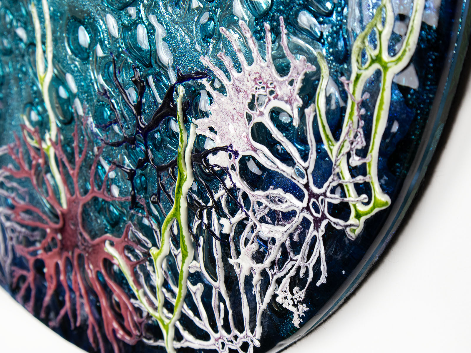 Details on a round fused glass wall panel, with hand-painted john dory design in vibrant organic colours and textures. 