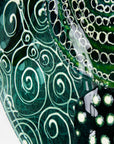 Close up of fused glass round panel, handmade using ocean colours and botanical and organic painted designs. An abstract, coastal inspired piece of wall art. 