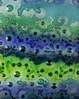A close up of the details designed on a fused glass staggered triptych featuring an ocean inspired design, with a blend of coastal blues and sea greens, handmade with organic bubbled texture. 
