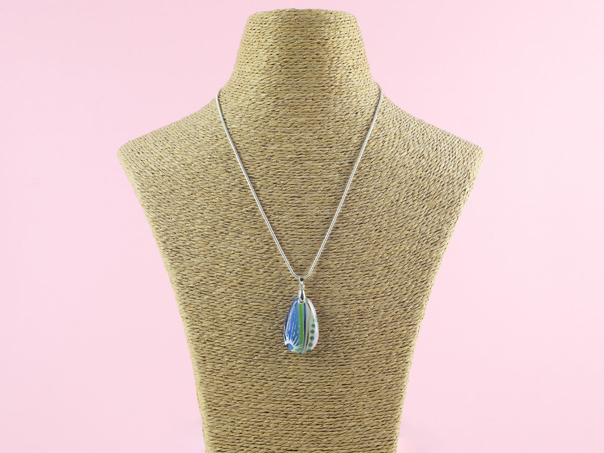 A Signature by Jo Downs fused glass pendant necklace, handmade using some of Jo's innovative techniques in soft botanical and ocean colours. Finished with a sterling silver chain and fittings, shown on a mannequin. 