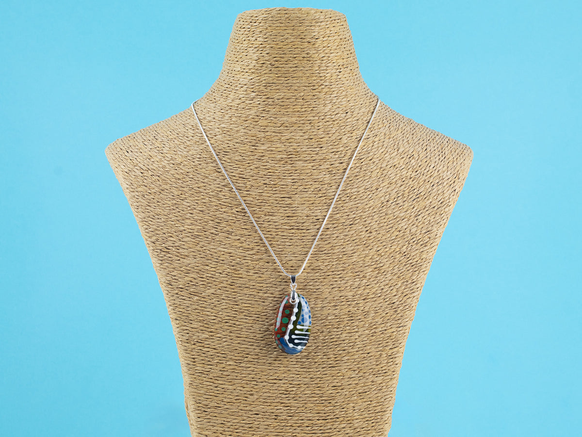 Fused glass pendant necklace handmade in rich coastal and sunset hues, including hand-painted patterns and hung on a sterling silver chain.