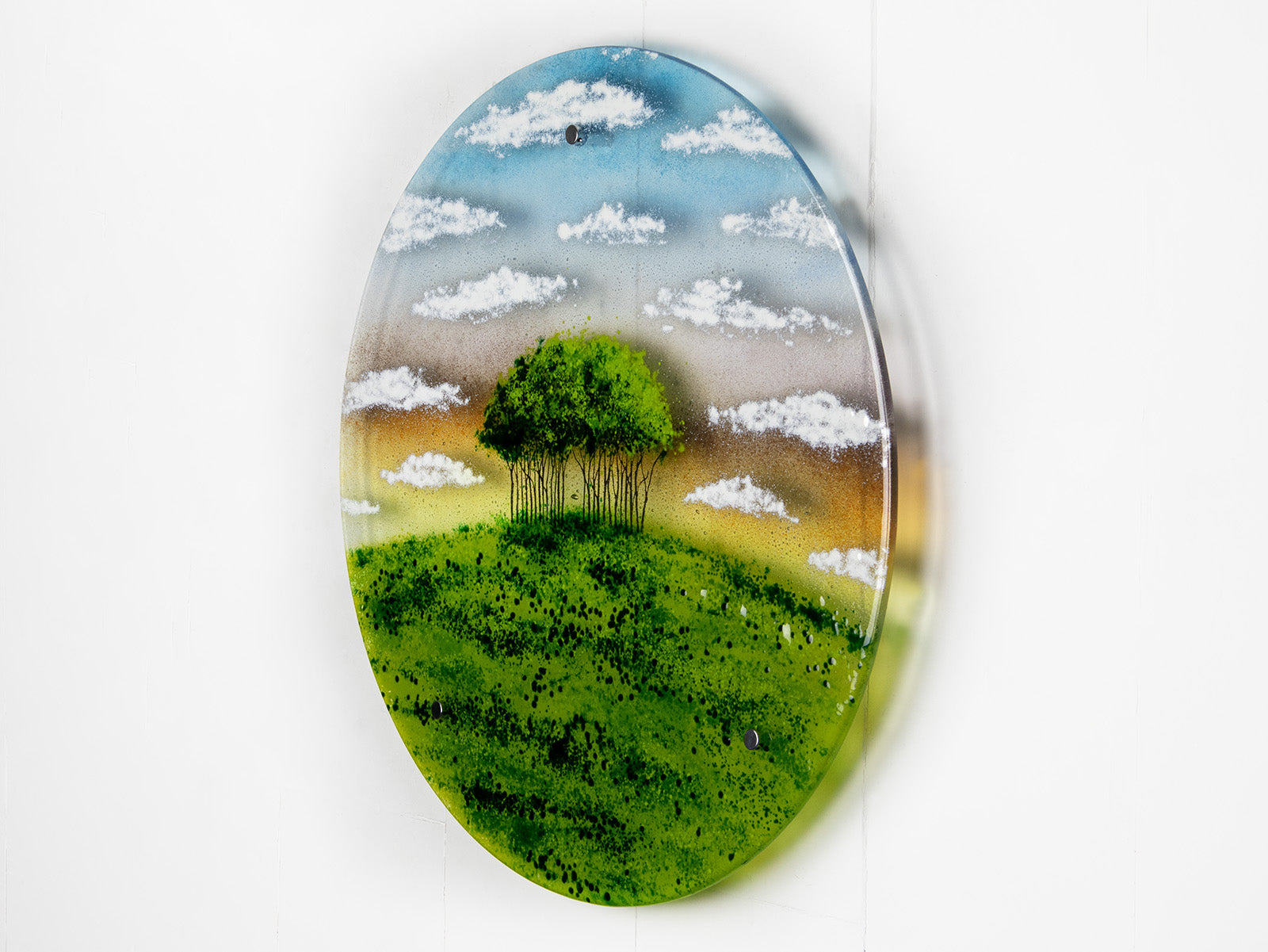 A fused glass round panel featuring a design of the "Nearly Home Trees" located on a hill over-looking the A30. 