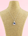 A fused glass pendant necklace, handmade in rose pinks, with dark blues hues, hung on a sterling silver chain.  