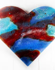 A striking 95cm fused glass hear shaped wall panel handcrafted in Cornish studio in bright reds, aqua blues and lots of textured detailing. 