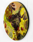 A fused glass round panel featuring organic autumn inspired patterns and shapes, in a vibrant yellow colour-way, handmade and inspired by the autumnal season. 