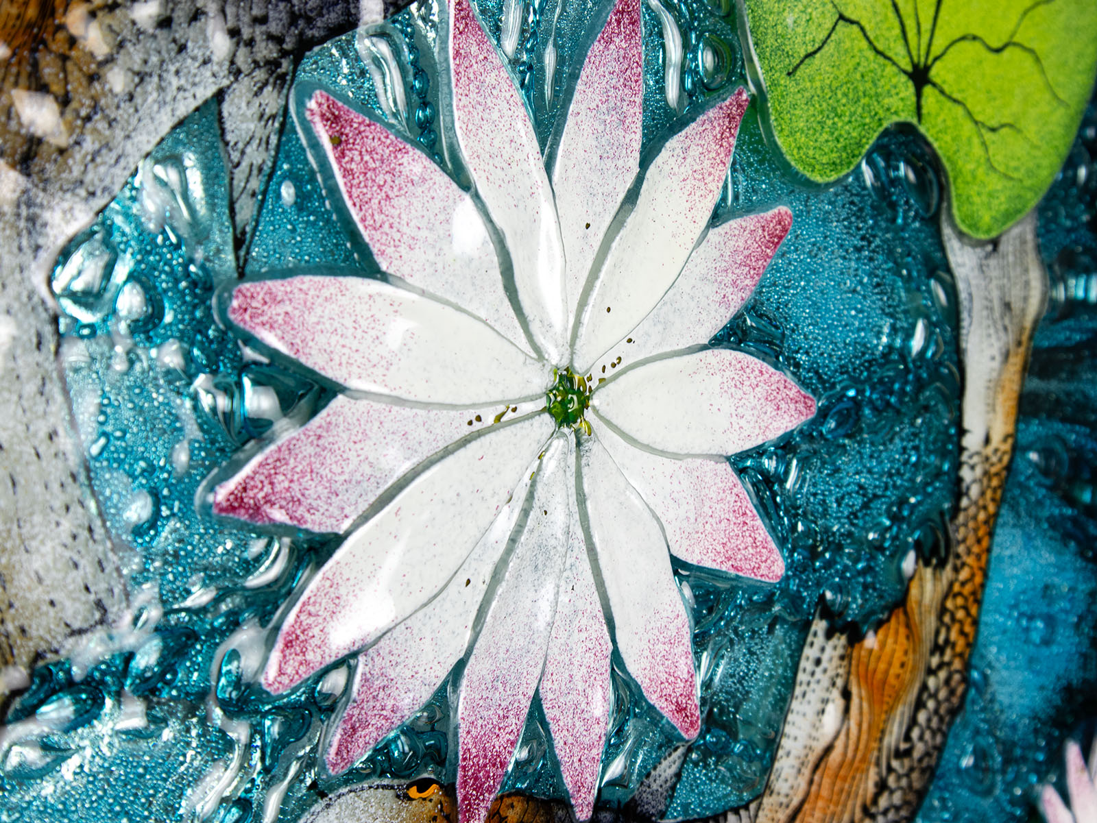 A detailed shot of the lily in a fused glass round panel featuring hand-painted koi carp design with waterlilies and marine blue background. 
