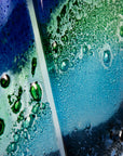 A close up of a fused glass quintych featuring an ocean blue colour-way, inspired by the coast.