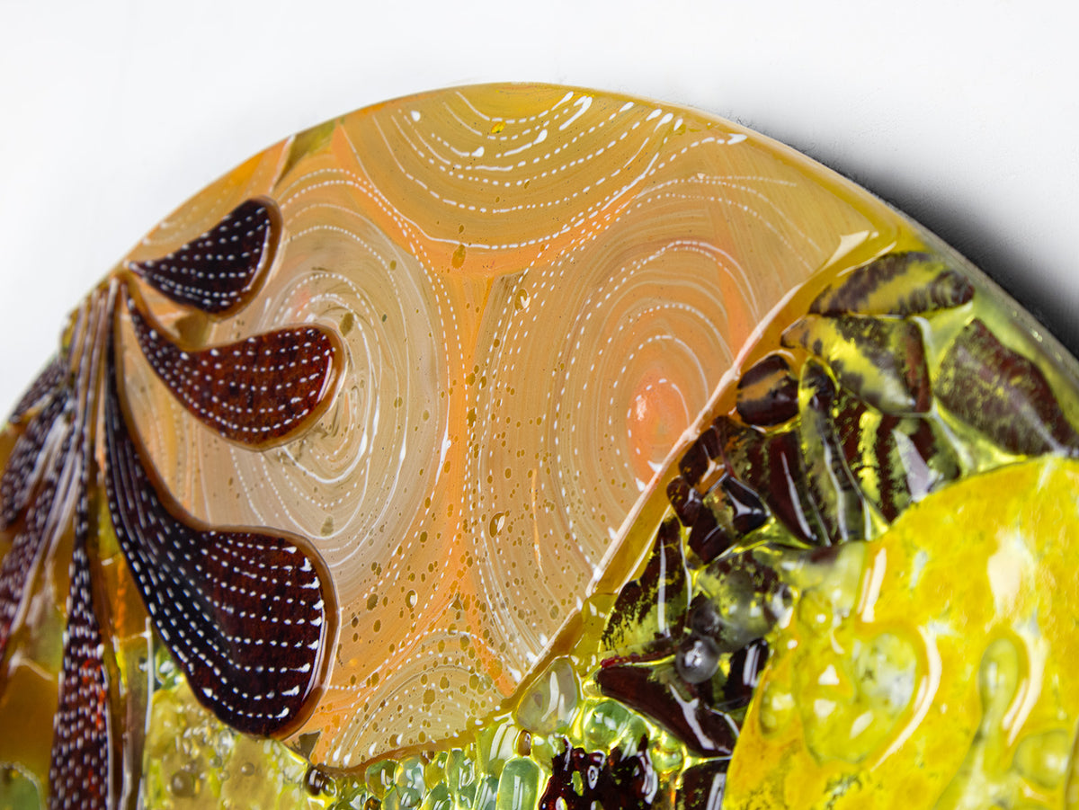 Hand-painted detailing on a fused glass round panel featuring organic autumn inspired patterns and shapes, in a vibrant yellow colour-way, handmade and inspired by the autumnal season. 