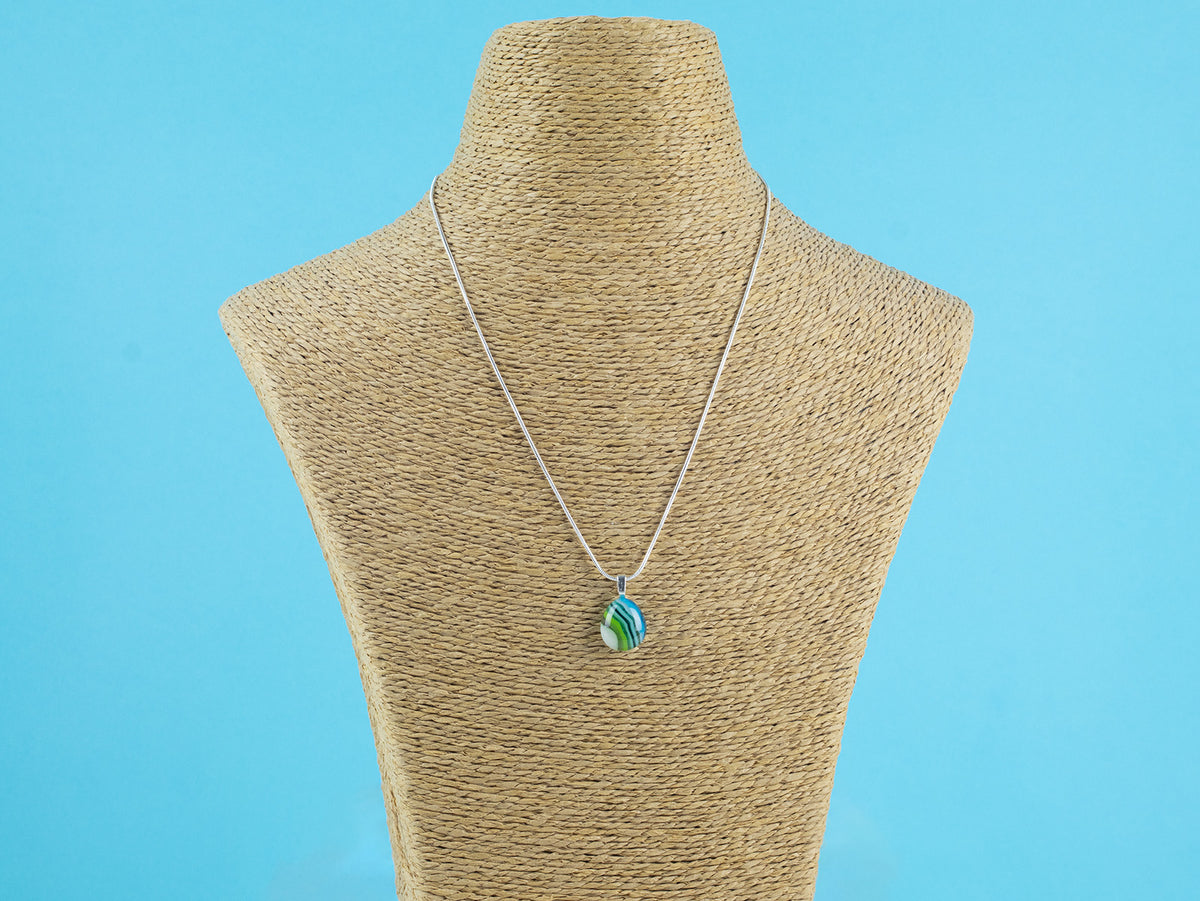 Fused glass small pendant necklace, handmade in ocean blue and green hues, hung on a sterling silver chain. 