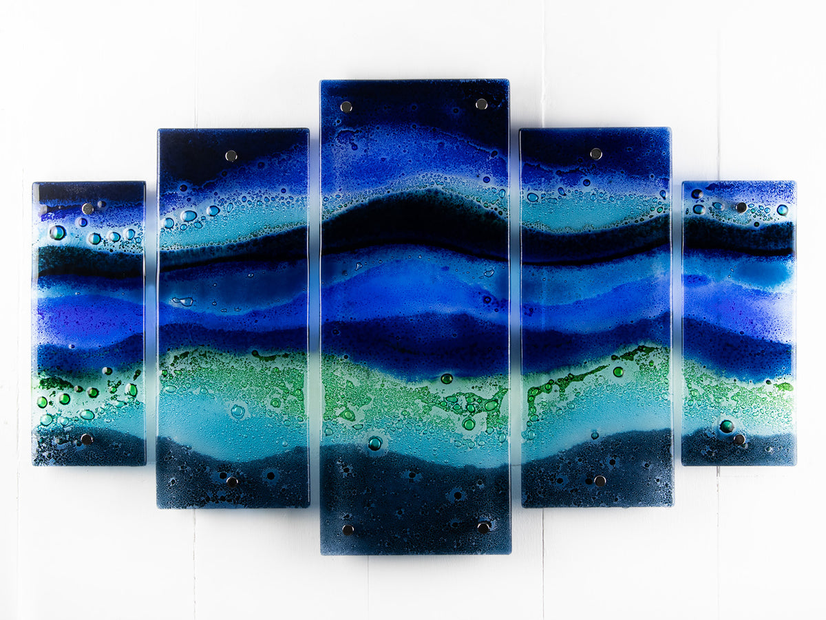 A fused glass quintych featuring an ocean blue colour-way, inspired by the coast.