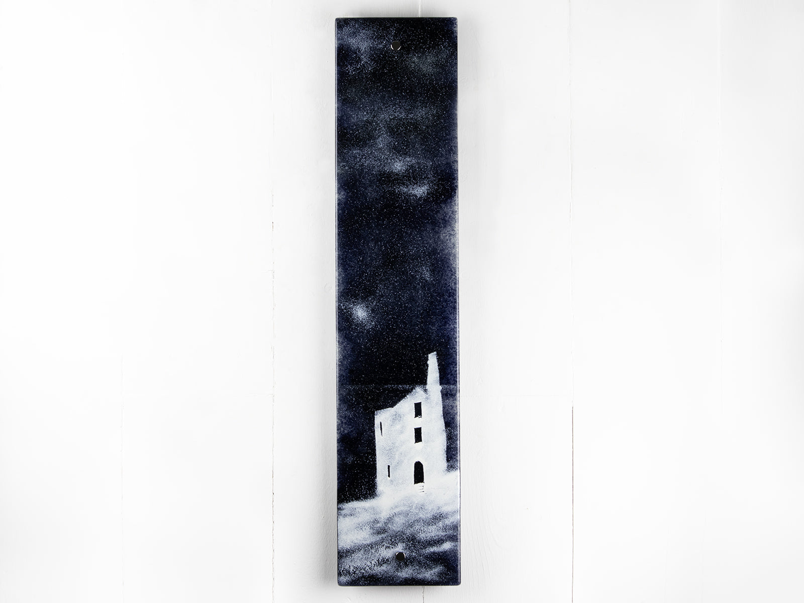 A fused glass panel featuring a monochrome design of a Cornish tin min. 