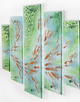 A fused glass quintych featuring a soft coastal colour-way with darting copper fish and bubbled detailing. An ocean inspired piece of wall art. 