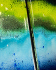 Close up of fused glass staggered triptych in bright rainbow colours, placed onto mirror glass. A vibrant piece of wall art. 