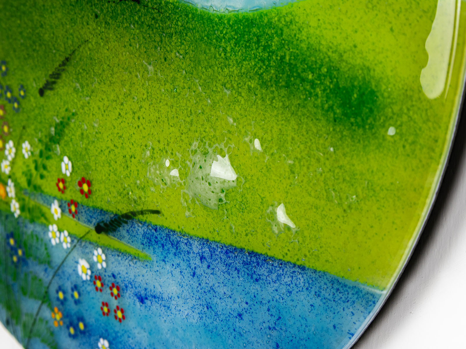 Close up of a bubble on a fused glass round panel, inspired by the Nearly Home Trees in Devon, designed in bright summer greens. 
