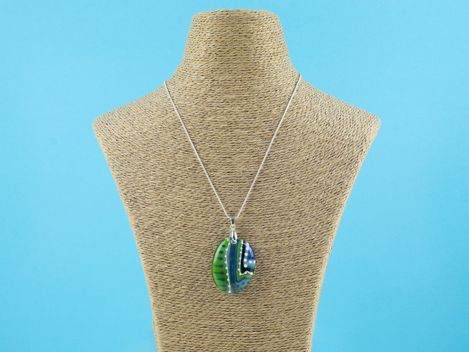 Fused glass pendant necklace, with hand-painted dots and swirls, in an ocean blue and green colour-way. Pendant is hung on a sterling silver chain. 
