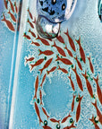 Details of the fish featured on a fused glass staggered triptych wall display, handmade in bright ocean blues and aquas, in a coastal rock-pool design, featuring copper fish. 