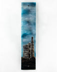Fused glass tin mine wall panel set against a moody dark sky, creating a soft Cornish inspired piece of wall art. 