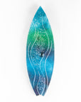 A surfboard-shaped wall art piece featuring a sea blue and green colour-way with soft waves and textured detailing. 