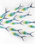 Fused glass ocean shoal of fish, in bright coastal yellows, purples, greens and blues. A vibrant ocean inspired wall art display. 