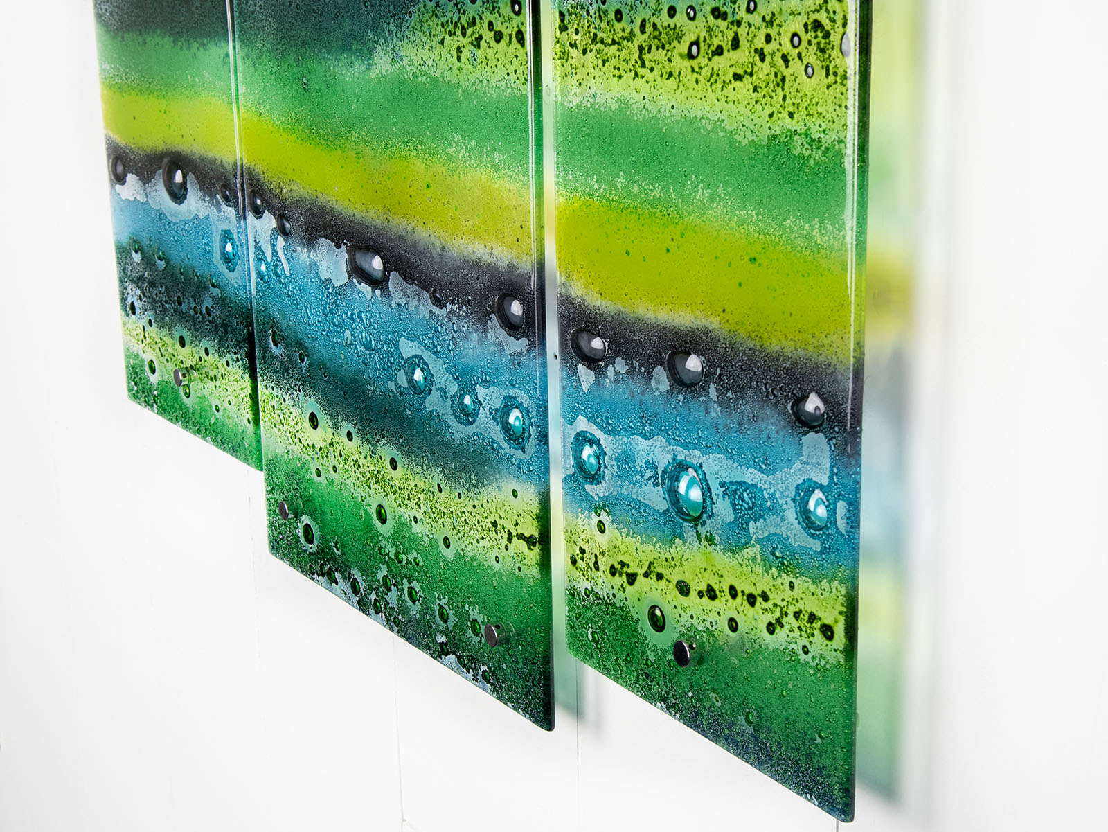 Fused glass triptych featuring an organic green design with bubbled detailing, handmade in emerald green colours. 