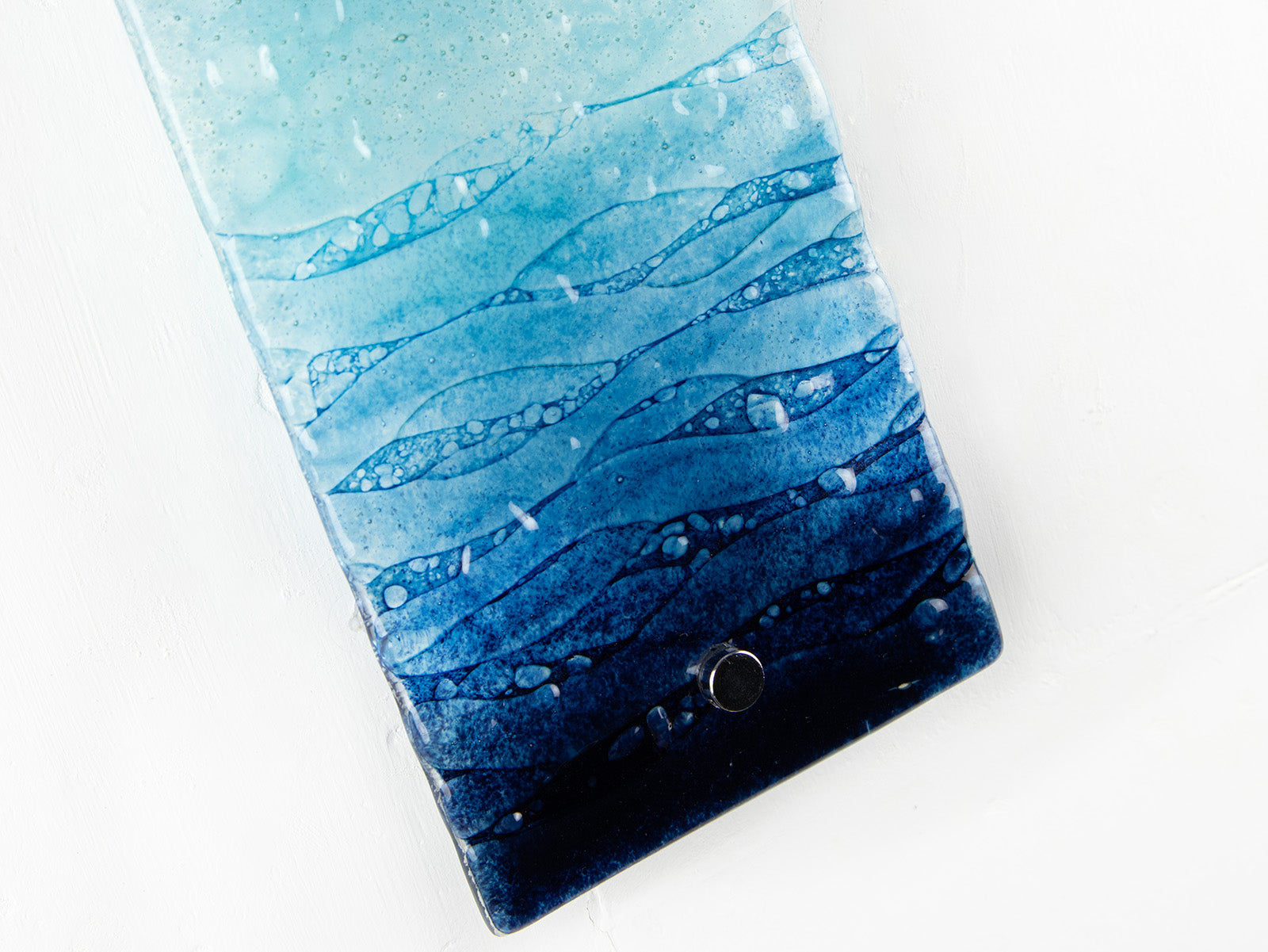 Details of marine blue waves on a fused glass wall panel. 
