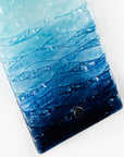 Details of marine blue waves on a fused glass wall panel. 