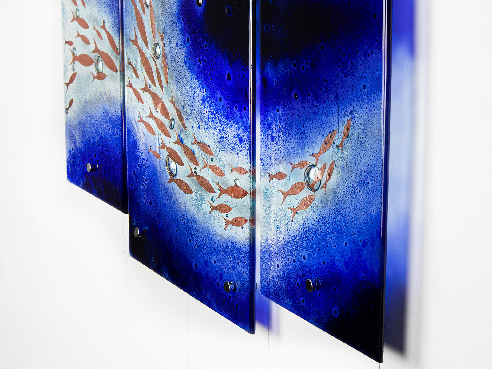 Fused glass triptych featuring a royal blue colour-way, with swirling copper fish, handmade in a beautiful ocean inspired design. 