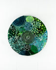 Fused glass round panel, handmade using ocean colours and botanical and organic painted designs. An abstract, coastal inspired piece of wall art. 