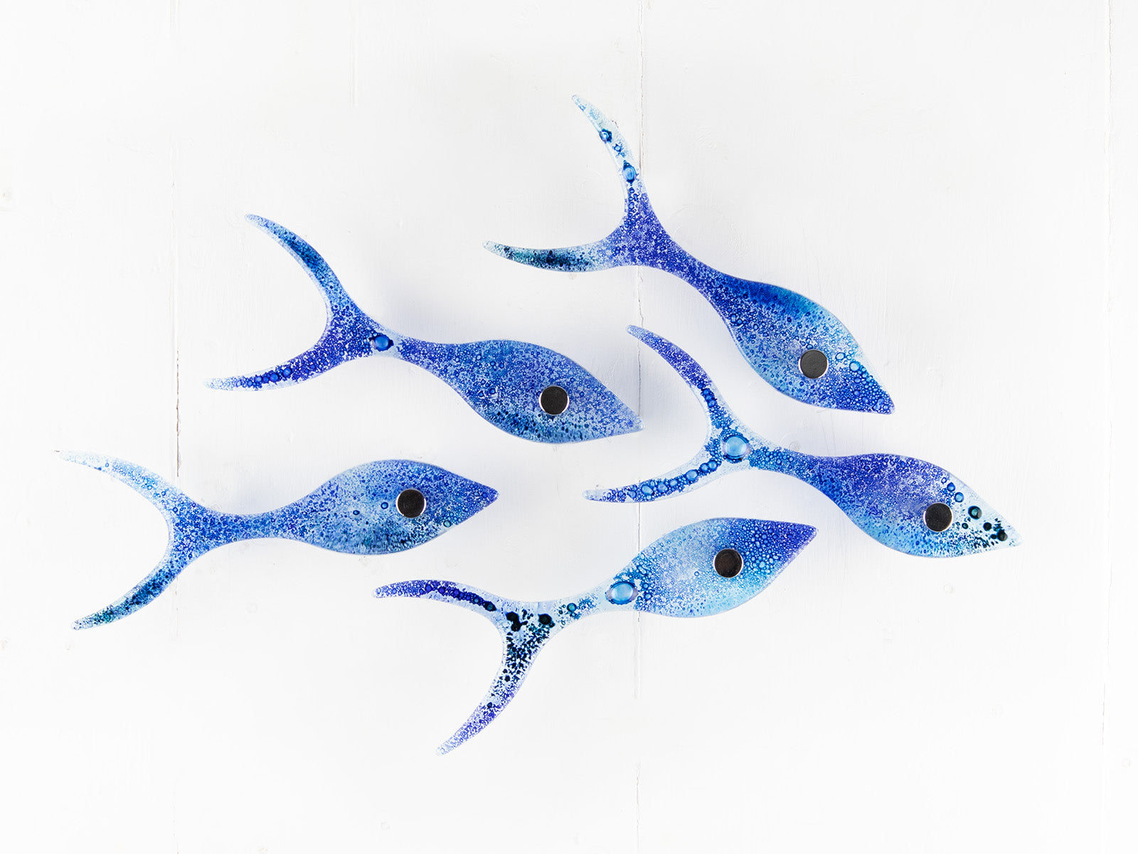 Small fused glass shoal of fish, handmade in coastal blue colours with organic bubbled detailing. 
