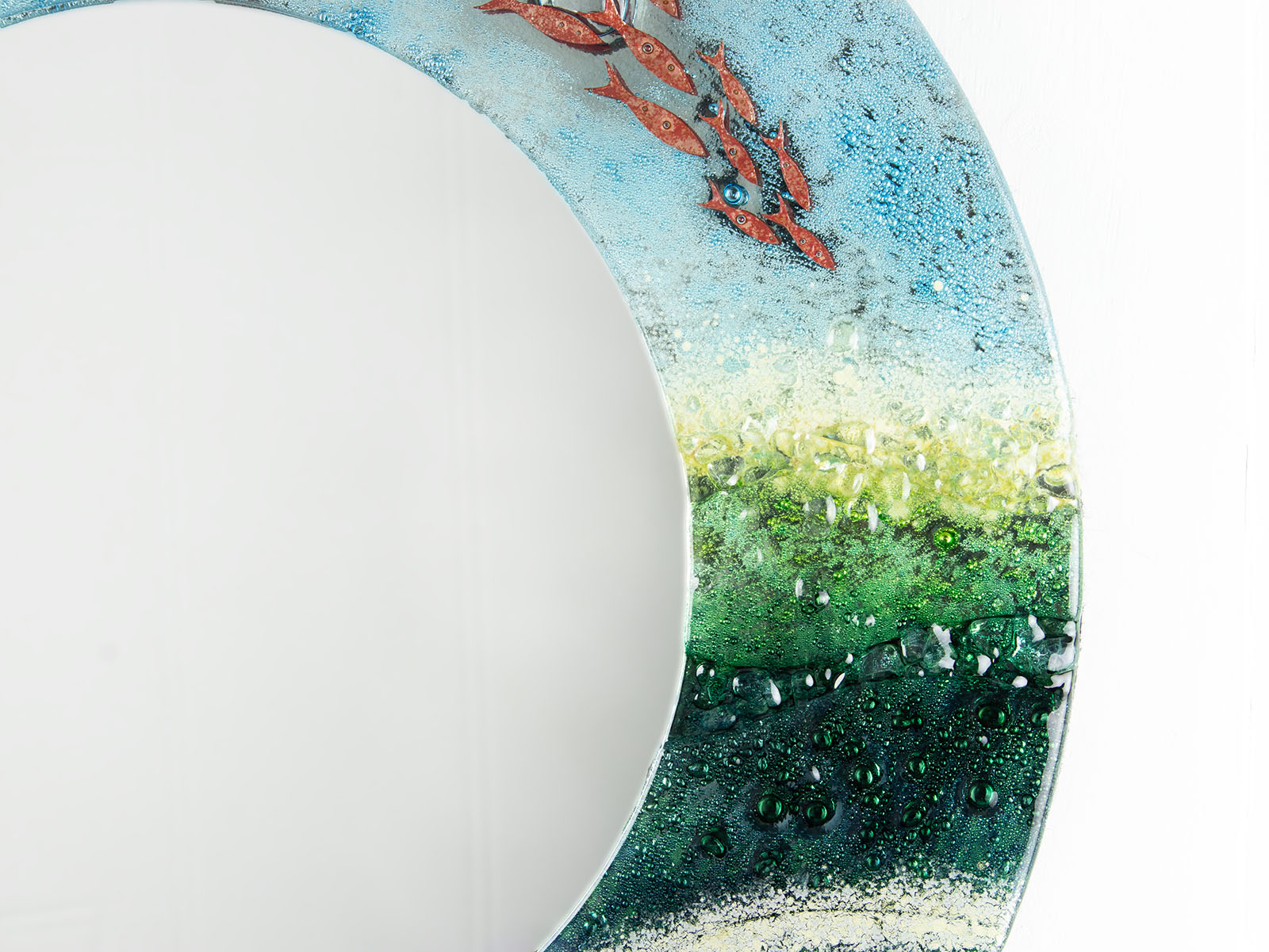 close up of fused glass round mirror with ocean inspired design and copper fish detailing. Handmade, bespoke wall art. 