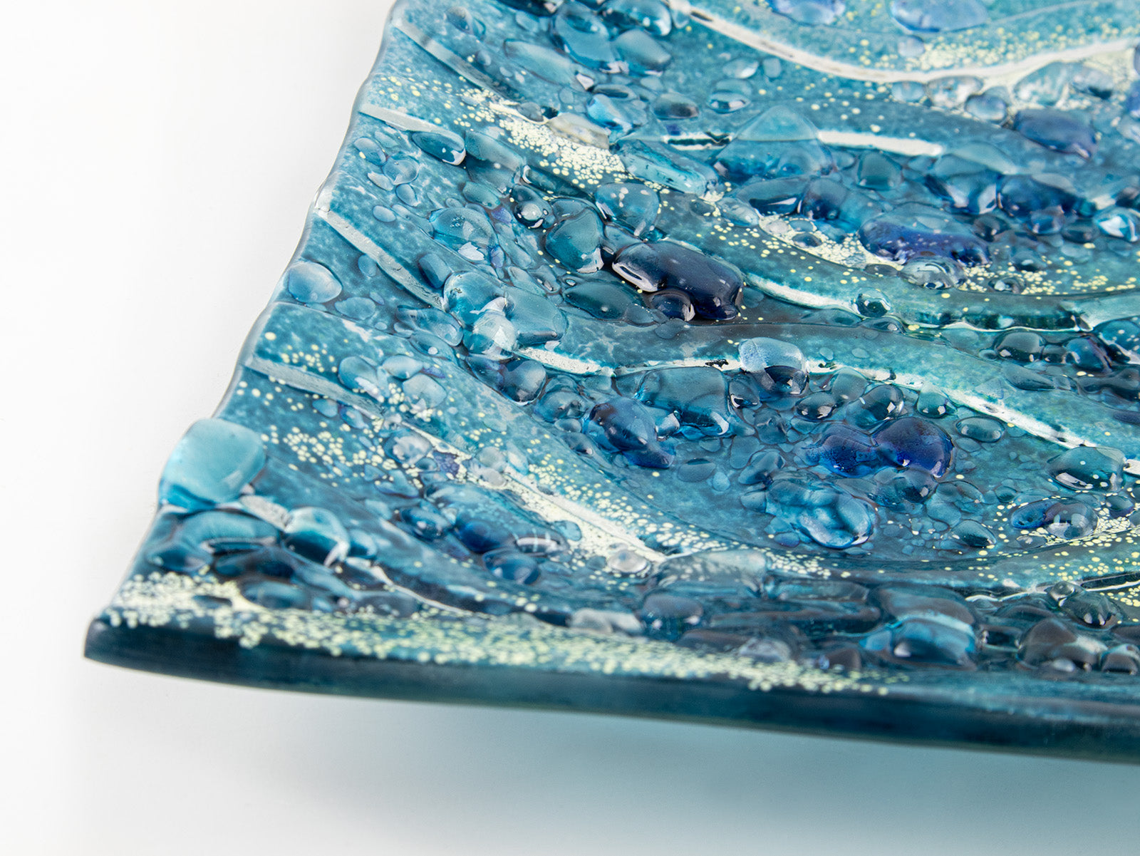 close-up of fused glass square bowl textured blue teal 
