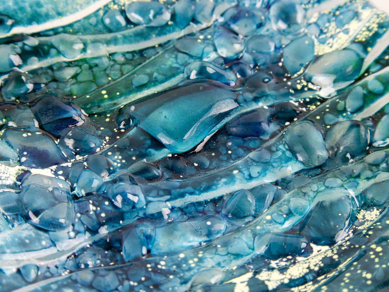 Close-up of blue teal fused glass sqaure bowl textured surface