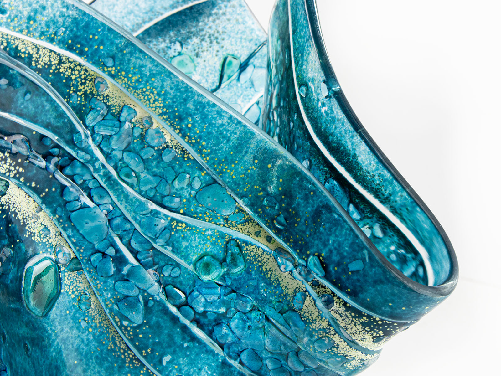close-up of fold form fused glass vase textured blue teal