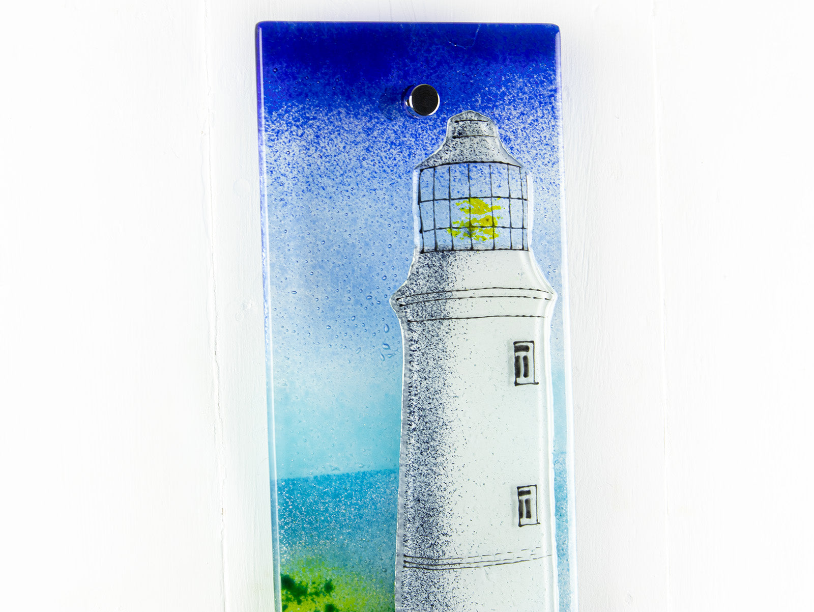 Close up of a lighthouse design on a fused glass wall panel. 