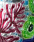 Detailing of fused glass round wall panel with hand painted design of a coral reef. Organic and vibrant ocean colours. 
