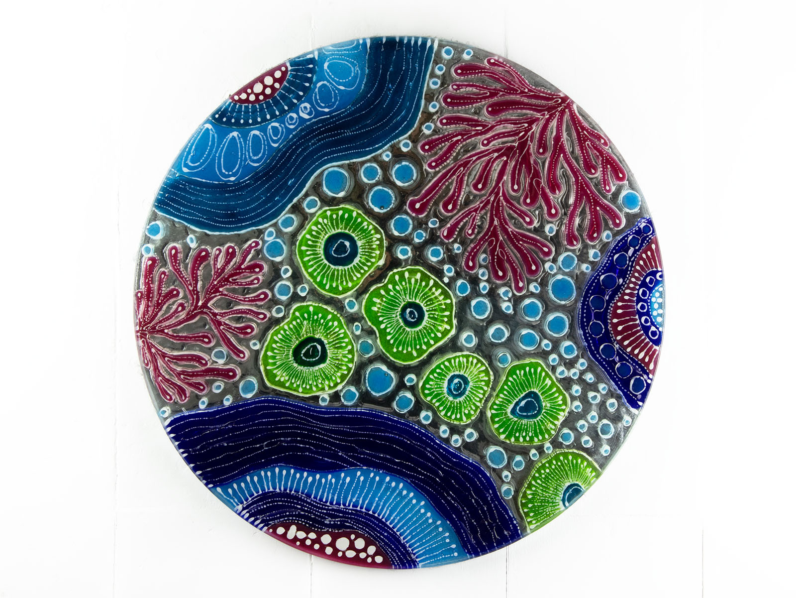 Fused glass round wall panel with hand painted design of a coral reef. Organic and vibrant ocean colours. 
