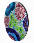 Fused glass round wall panel with hand painted design of a coral reef. Organic and vibrant ocean colours. 