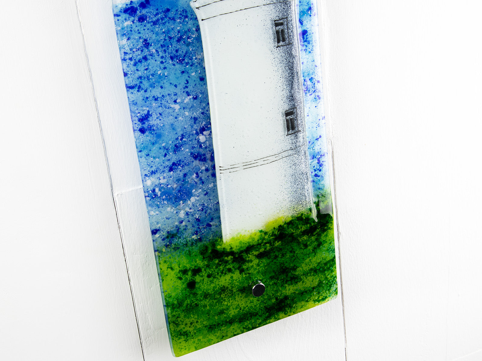 Details of fused glass wall panel with lighthouse design. Handmade made in Cornish studio in coastal colours.