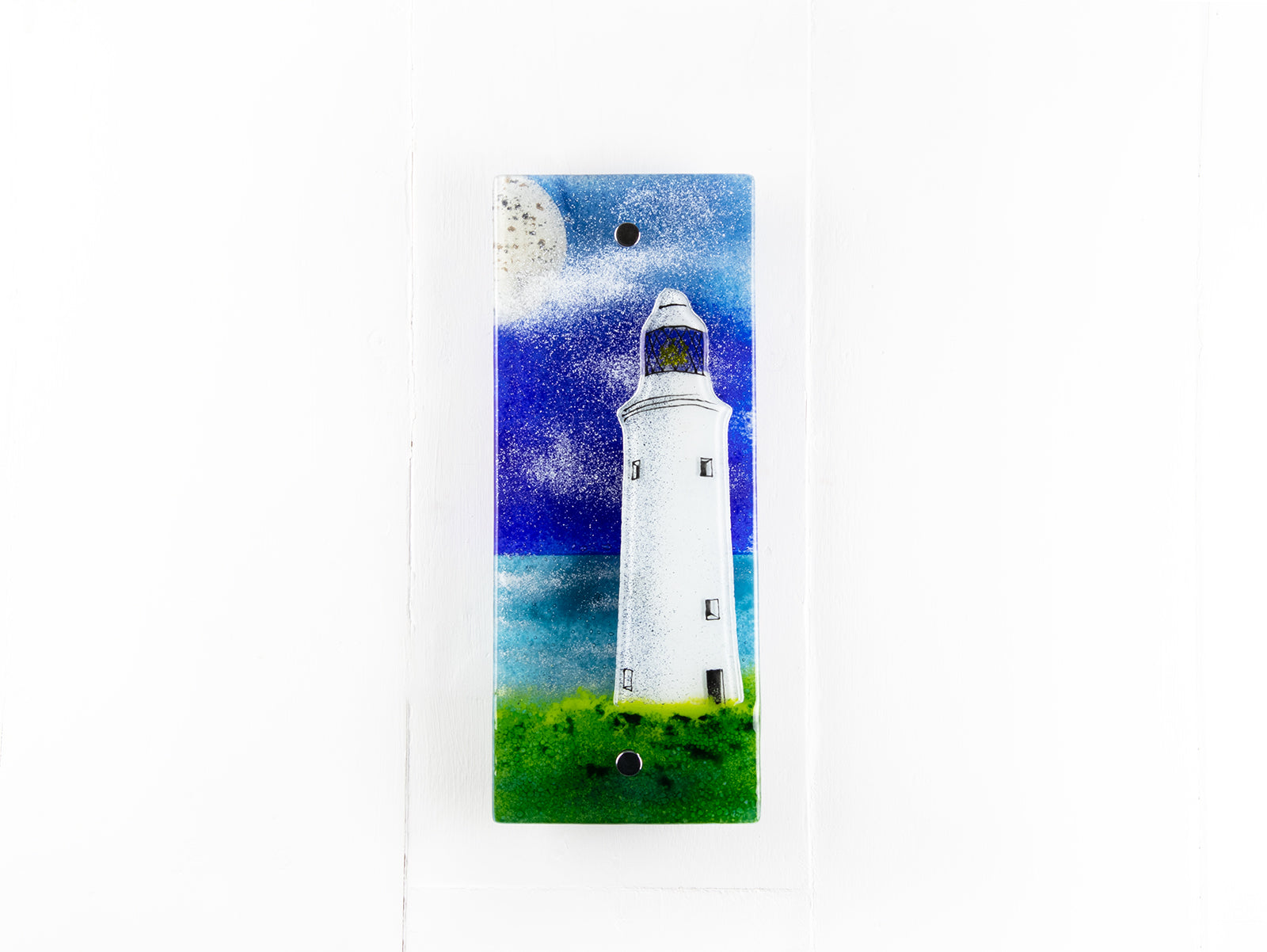 Fused glass wall panel with lighthouse and moon design in coastal colours. Handmade glass panel, designed in Cornwall. 