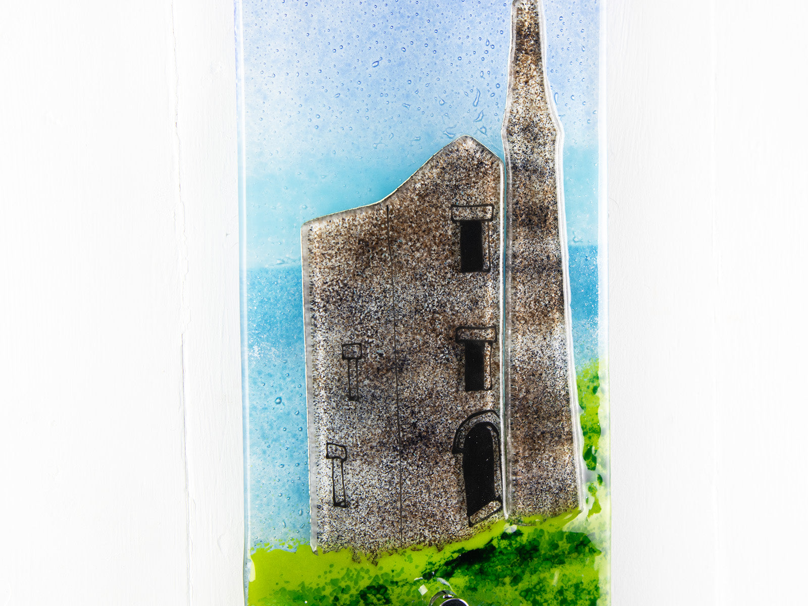 Close up of tin mine on a fused glass wall panel with Cornish coastal colours. A handmade piece of glass wall art. 