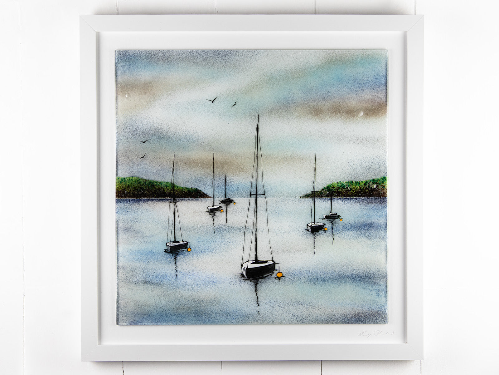Fused glass piece of wall art, featuring a design of a harbour and sailing boats, in soft coastal colours. 