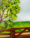 Close up of fused glass art frame with a countryside scene in vibrant colours, focused on a spring tree. 