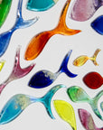 Details of individually hand-cut fused glass fish in rainbow hues on a white art frame.