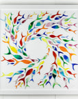 Individually hand-cut fused glass fish in rainbow hues on a white art frame.