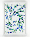 Shoal of fish with individual hand-cut fused glass fish in marine blues on white art frame. An ocean inspired piece of wall art. 