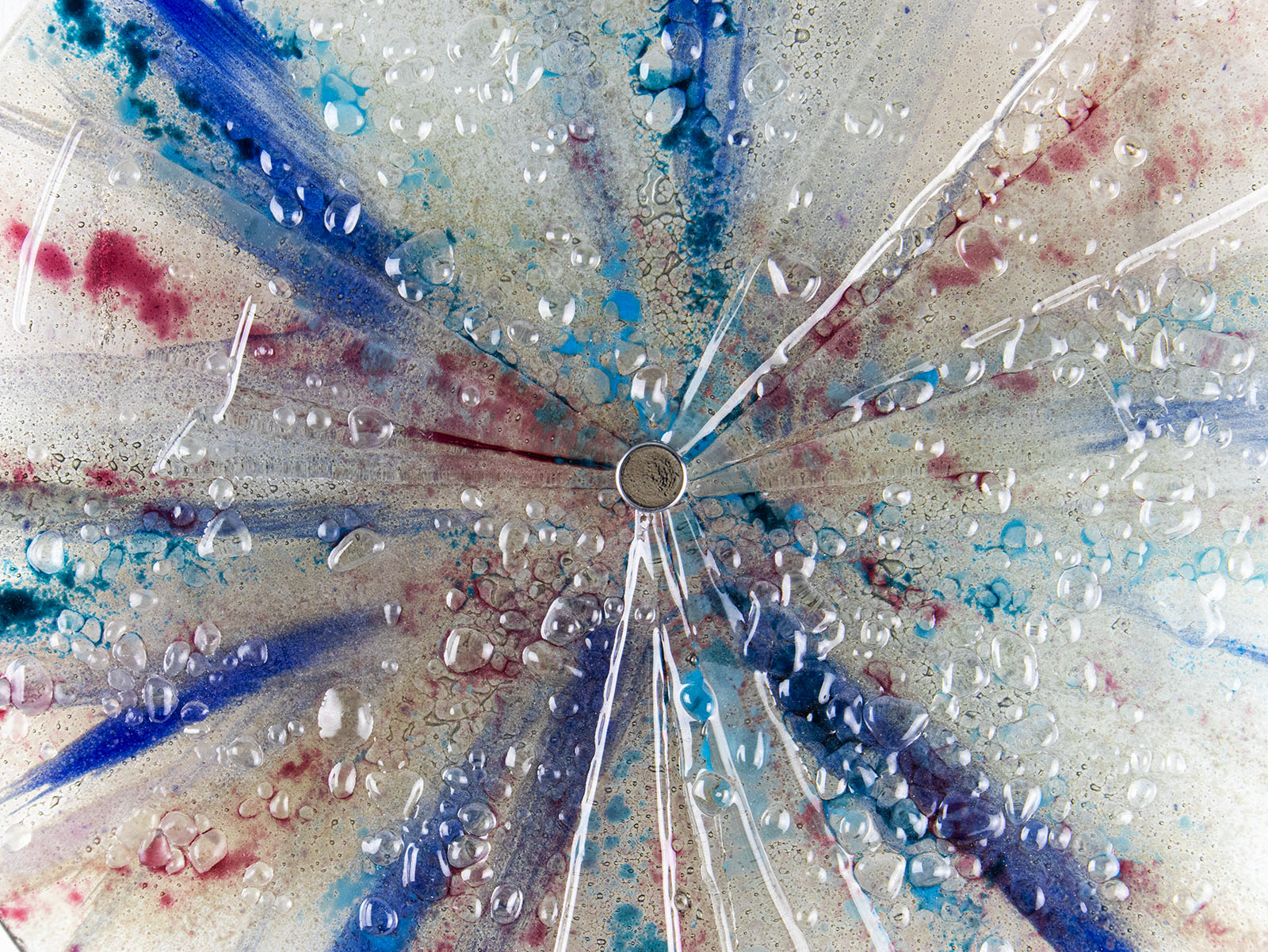 Textured details of fused glass circular panel featuring soft, coastal colours.